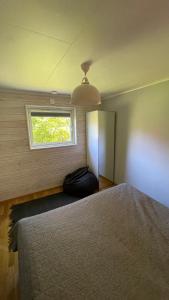 FlodaFloda, Minihus på 62m2 för plats för 4 vuxna och 2 barn的一间卧室设有一张大床和一个窗户。