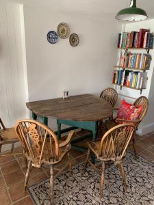 布鲁顿Charming townhouse in Bruton的一间带木桌和椅子的用餐室