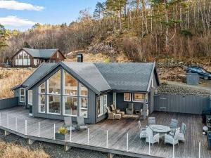 灵达尔Holiday home lyngdal VI的房屋设有1个带桌椅的甲板