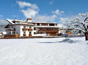 瓦尔道拉阿尔普克龙莫亚里霍夫酒店的雪中的房子,有雪覆盖的院子