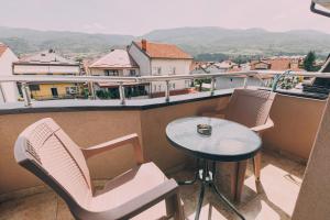 奥赫里德VILLA EKATERINA的设有一个配有桌椅并享有美景的阳台。