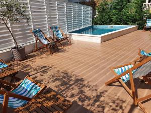 布德瓦Sun and Sea Apartments的一个带三把椅子的庭院和一个游泳池