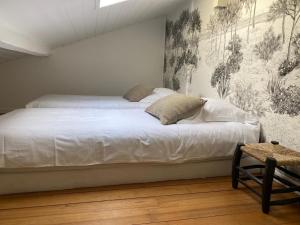 卡普费雷villa blanche Cabine 1的卧室内的一张白色床,配有壁画