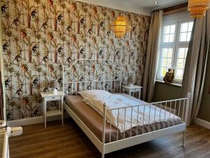 巴尔辛格豪森Gästehof Cafe im Schafstall的一间卧室配有一张带花卉壁纸的床