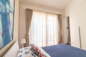 里米尼Suite Frida Rimini的一间卧室设有蓝色的床和窗户。