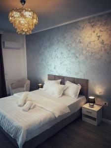 北马马亚-讷沃达里The Chalet的卧室配有一张带吊灯的大型白色床。