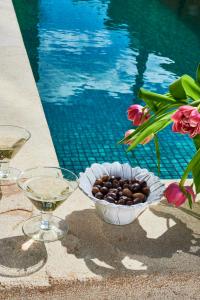 菲盖拉-达福什Vila Branca Guesthouse - Palacete的游泳池旁的葡萄和酒杯碗