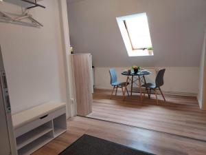 Apartment 1 Unter den Eichen的客房设有桌椅和窗户。