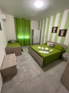 阿格里真托Le Camere Del Villaggio的一间卧室设有两张床,并拥有绿色和白色的条纹