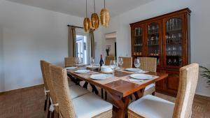 珀彻斯Luxury Villa With Pool in Vineyard Near the Beach的一间带木桌和椅子的用餐室
