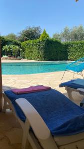 La Roquette-sur-Siagne2 Pièces Rdc Villa Piscine的一个带2把躺椅和蓝色毯子的游泳池