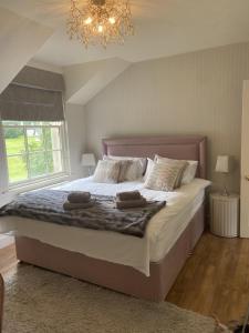 BallycassidyGate lodge at Lough Erne Golf Village的一间卧室配有一张大床和两条毛巾
