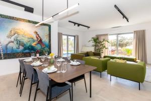 ŠkripLuxury house Natanel的一间带桌子和绿色椅子的用餐室