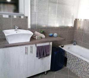 斯普林斯Greystoke - Furnished, self service apartment.的浴室配有盥洗盆和浴缸。