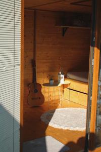 DechticeV dedine a predsa mimo nej v maringotke na samote的一间设有吉他、桌子和床的房间