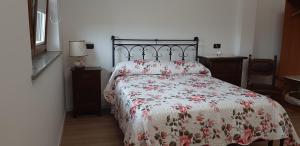 SantenaCASCINA LAI - Oasi Naturalistica - Camere private的一间卧室配有一张带花卉床罩的床