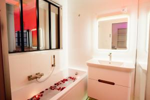 蒙托邦room five - parking, balnéothérapie, place nationale, un havre de paix的浴室设有水槽和浴缸,地板上设有心形浴缸。