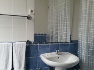 库里亚盘扫洛伦索酒店的浴室设有白色水槽和镜子
