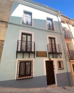 昆卡Ateneo Cuenca的白色的建筑,设有黑色的阳台和门