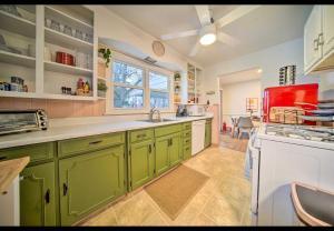 伊利Modern Home • Family Friendly • Grill • Fireplace的厨房配有绿色橱柜和红色用具