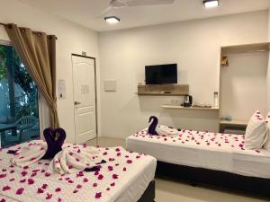 图杜Lagoon Villa Thoddoo的两张床位于带心灵的房间
