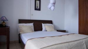 MutsamuduOcéanis Hotel的卧室配有一张带白色床单和枕头的大床。