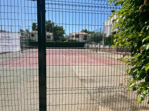 贝尼卡西姆Adosado con piscina y tenis的一座网球场,通过链条围栏