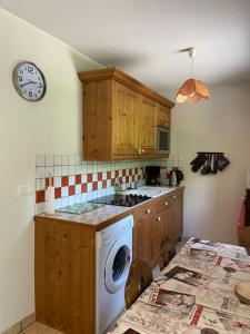 萨莫安斯Les Frahans的厨房配有洗衣机和墙上的时钟