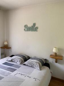 萨莫安斯Les Frahans的卧室配有一张挂着微笑标志的床铺