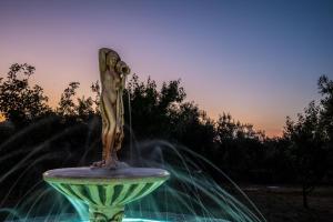 斯科派洛斯Giasemi Apartments的坐在喷泉顶上的女人雕像