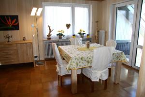 洪堡Ferienwohnung Klosterblick的一间带桌子和白色椅子的用餐室