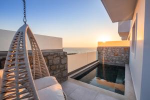 卡尔帕索斯Thalasidi Luxury Suites的一座带秋千和游泳池的房子
