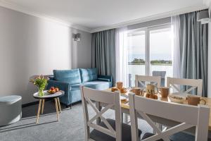 弗瓦迪斯瓦沃沃Belmar Park Resort & SPA的客厅配有桌子和蓝色沙发