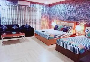 拉合尔Pace view Hotel Gulberg,Lahore的一间卧室配有两张床和一张沙发。