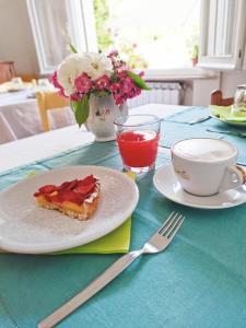 里乔内BeeLiving Room&Breakfast的一张桌子,上面放着一盘馅饼和一杯茶