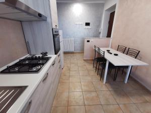 都灵HappyHome, Belissimo appartamento in Torino的厨房配有炉灶和桌椅