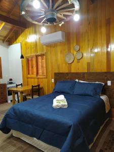 圣若阿金Aconchego da Serra Geminados的一间卧室配有蓝色的床和2条毛巾