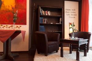 帕德博恩海德住宅酒店的客厅配有桌子、两把椅子和书架