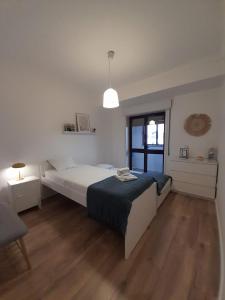 伊利亚武Amália Rodrigues -apartamento com 3 quartos em pleno coração de Ílhavo的白色的卧室设有床和窗户