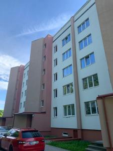 罗亚Torņa apartamenti的停在大楼前的红色汽车