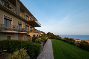 因佩里亚Villa LeA的一座带绿色草坪的建筑,毗邻大海