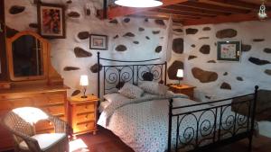 TemisasLa Casa de los Pinos Temisas的一间卧室设有一张床和一面岩石墙