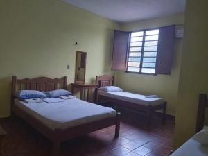 博阿维斯塔Hotel Ideal的一间卧室设有两张床和窗户。