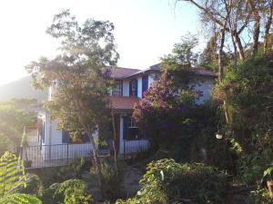 欧鲁普雷图Solar dos Reis Apartamento Topázio的前面有树木和鲜花的房子