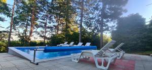 Velika RemetaVila Sinfonia, a house with a pool的一组椅子坐在游泳池旁