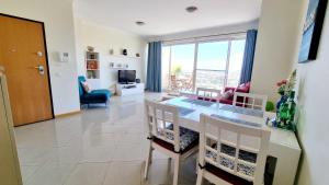 阿尔布费拉Sea View Penthouse in Albufeira的厨房以及带桌椅的起居室。