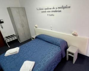 卡斯特罗卡罗泰尔梅Hotel Villa Serena的卧室配有一张床,墙上有标志
