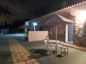 圣玛丽亚港Los Duendes的晚上在庭院里摆放着桌椅和遮阳伞