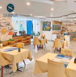 胡志明市Sabina Boutique Hotel 2的一间在房间内配有桌椅的餐厅