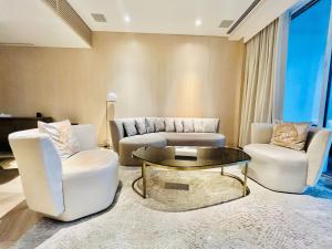 迪拜FIVE Palm Jumeirah Resort - 2 Bedrooms plus Maids and Private Jacuzzi - ModernLux的客厅配有两把椅子和一张茶几